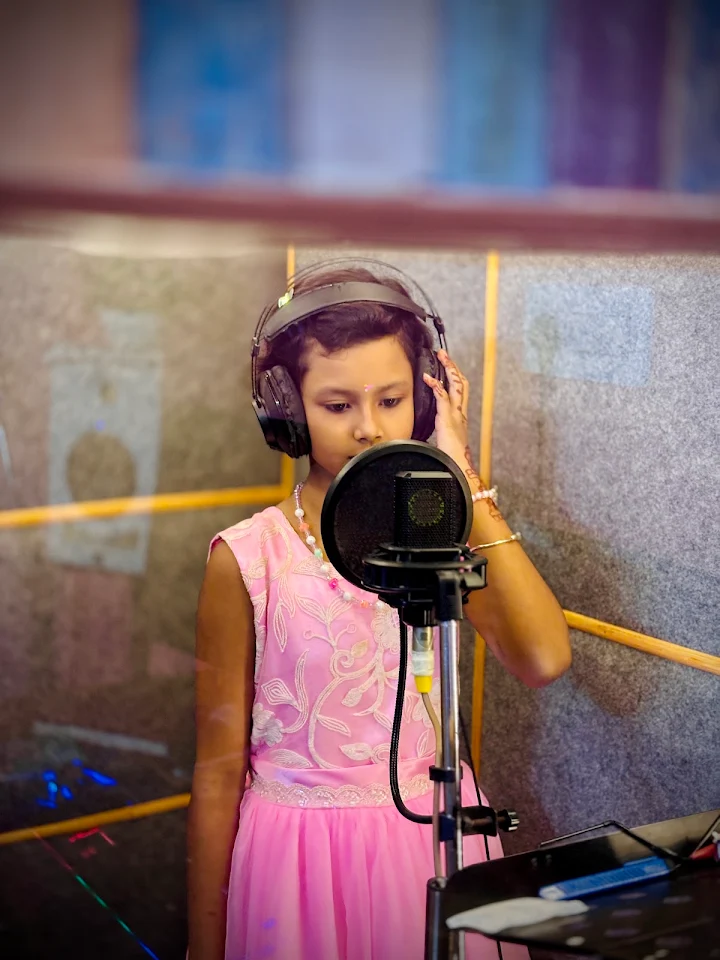 Young singer holding her headphones at the microphone
